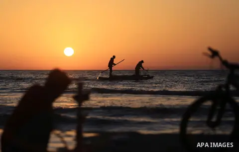 Palestinains ride a boat during sunset at the beach of the Mediterranean sea on the coast of Gaza city on April 17, 2016. Photo by Yasser Qudih