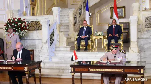 Egyptian President Abdel Fattah al-Sisi (rear R) and his French counterpart Francois Hollande look on during a ceremony marking the signing of several economic agreements at al-Quba Presidential Palace, in Cairo, Egypt A...