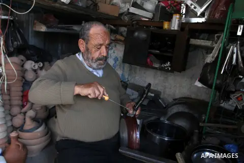 A Palestinian man works at his work-shop in a market in Rafah in the southern Gaza strip, April 19, 2016. Photo by Abed Rahim Khatib