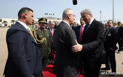Algerian Prime Minister Abdelmalek Sellal shake hands with Palestinian Prime Minister Rami Hamdallah before leaving Algerian Houari Boumediene International Airport in the capital Algiers on April 19, 2016. Photo by Prim...