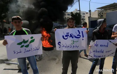 Palestinian owners of houses which were destroyed during the recent Israeli war, burn tires during a protest, in front of high commissioner for human rights headquarters, in Gaza City on April 20, 2016. Israeli occupatio...
