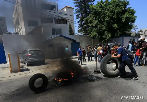 Palestinian owners of houses which were destroyed during the recent Israeli war, burn tires during a protest, in front of high commissioner for human rights headquarters, in Gaza City on April 20, 2016. Israeli occupatio...