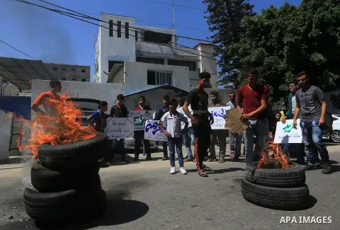 Palestinian owners of houses which were destroyed during the recent Israeli war, burn tires during a protest, in front of high commissioner for human rights headquarters, in Gaza City on April 20, 2016. Israeli occupatio...