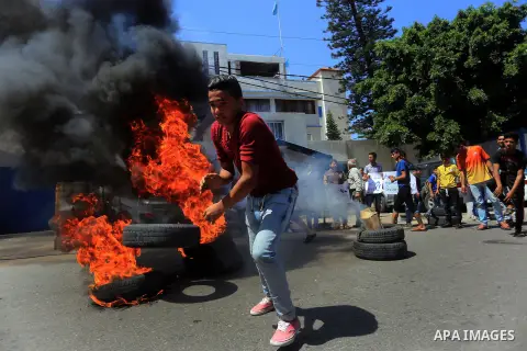 Palestinian owners of houses which were destroyed during the recent Israeli war, burn tires during a protest, in front of high commissioner for human rights headquarters, in Gaza City on April 20, 2016. Israeli occupatio...