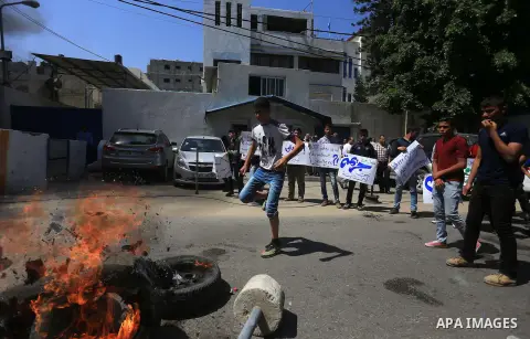Palestinian owners of houses which were destroyed during the recent Israeli war, burn tires during a protest, in front of high commissioner for human rights headquarters, in Gaza City on April 20, 2016. Israeli occupatio...