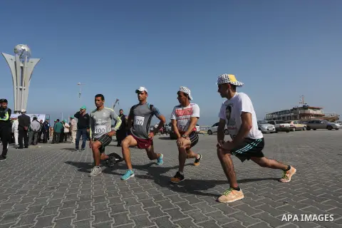 Palestinian youths take part in a marathon organized by Hamas and Fateh movement to mark Palestinian Prisoner Day, in Gaza city, on April 23, 2016. Photo by Mohammed Asad