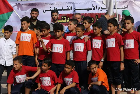 Palestinian youths take part in a marathon organized by Hamas and Fateh movement to mark Palestinian Prisoner Day, in Gaza city, on April 23, 2016. Photo by Mohammed Asad