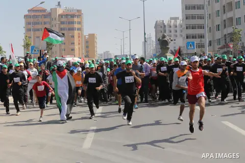 Palestinian youths take part in a marathon organized by Hamas and Fateh movement to mark Palestinian Prisoner Day, in Gaza city, on April 23, 2016. Photo by Mohammed Asad