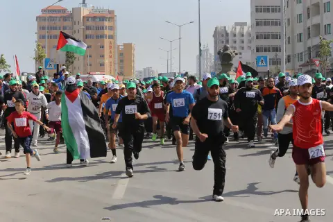 Palestinian youths take part in a marathon organized by Hamas and Fateh movement to mark Palestinian Prisoner Day, in Gaza city, on April 23, 2016. Photo by Mohammed Asad