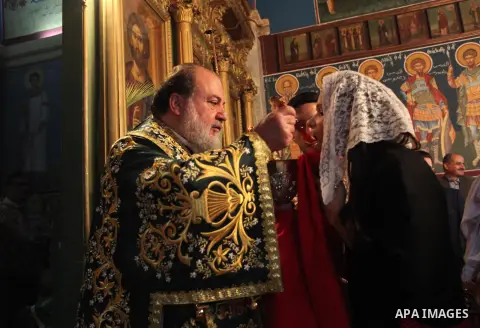 Reverend Archbishop of Tiberias, Alexios, gives the eucharist during the Greek Orthodox Christian Palm Sunday mass at St.Porphyrios Church in Gaza City, on April 24, 2016. Palm Sunday marks the triumphant return of Jesus...