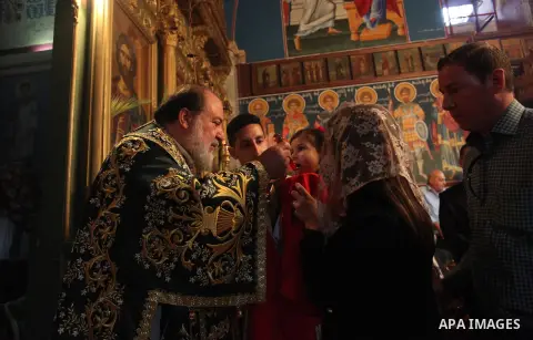 Reverend Archbishop of Tiberias, Alexios, gives the eucharist during the Greek Orthodox Christian Palm Sunday mass at St.Porphyrios Church in Gaza City, on April 24, 2016. Palm Sunday marks the triumphant return of Jesus...