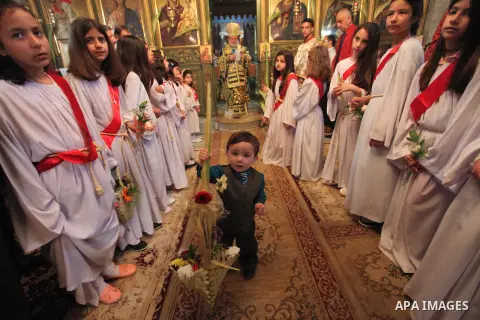 Reverend Archbishop of Tiberias, Alexios, gives the eucharist during the Greek Orthodox Christian Palm Sunday mass at St.Porphyrios Church in Gaza City, on April 24, 2016. Palm Sunday marks the triumphant return of Jesus...