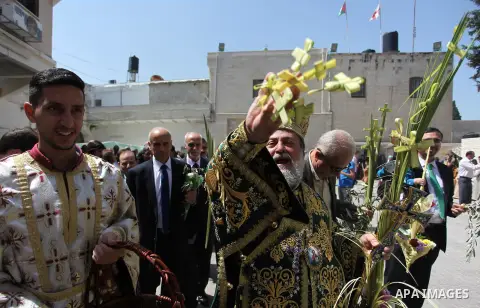 Reverend Archbishop of Tiberias, Alexios, gives the eucharist during the Greek Orthodox Christian Palm Sunday mass at St.Porphyrios Church in Gaza City, on April 24, 2016. Palm Sunday marks the triumphant return of Jesus...