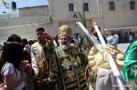 Reverend Archbishop of Tiberias, Alexios, gives the eucharist during the Greek Orthodox Christian Palm Sunday mass at St.Porphyrios Church in Gaza City, on April 24, 2016. Palm Sunday marks the triumphant return of Jesus...