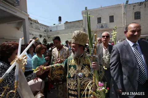 Reverend Archbishop of Tiberias, Alexios, gives the eucharist during the Greek Orthodox Christian Palm Sunday mass at St.Porphyrios Church in Gaza City, on April 24, 2016. Palm Sunday marks the triumphant return of Jesus...