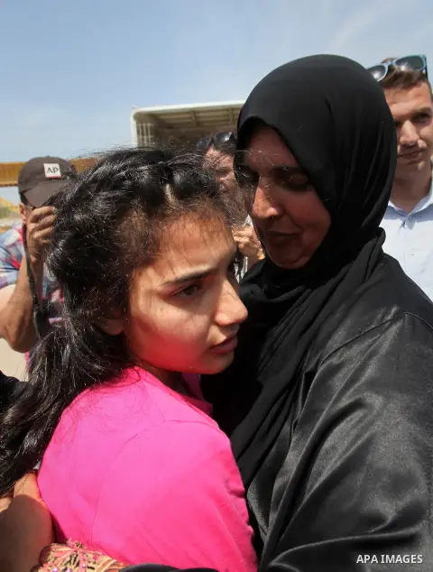 Released Palestinian prisoner Deema Al-Wawi, 12, who was detained by Israeli authorities for around two and half months, hugs her mother following her release near the West Bank city of Tulkarm April 24, 2016. Photo by N...