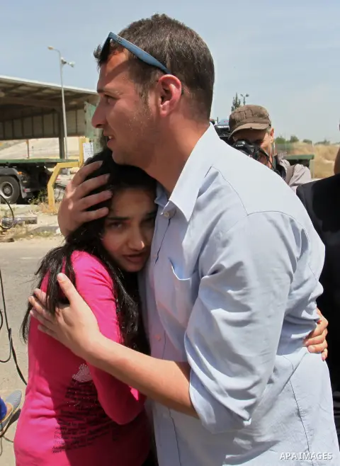 Released Palestinian prisoner Deema Al-Wawi, 12, who was detained by Israeli authorities for around two and half months, hugs her brother following her release near the West Bank city of Tulkarm April 24, 2016. Photo by...