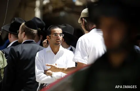 Israeli troops stand guard as Israeli settlers have a tour during the Jewish holiday of Passover in the West Bank city of Hebron, on April 25, 2016. Photo by Wisam Hashlamoun