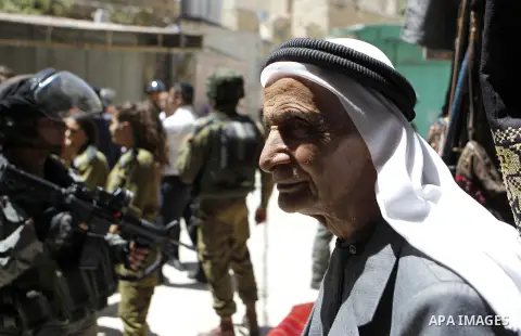 Israeli troops stand guard as Israeli settlers have a tour during the Jewish holiday of Passover in the West Bank city of Hebron, on April 25, 2016. Photo by Wisam Hashlamoun