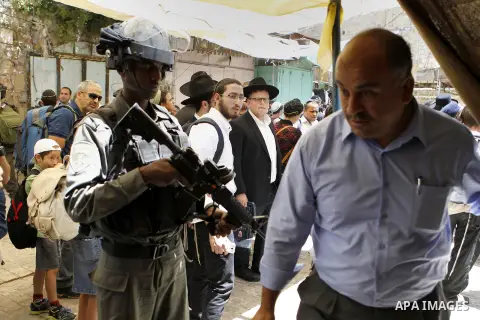 Israeli troops stand guard as Israeli settlers have a tour during the Jewish holiday of Passover in the West Bank city of Hebron, on April 25, 2016. Photo by Wisam Hashlamoun