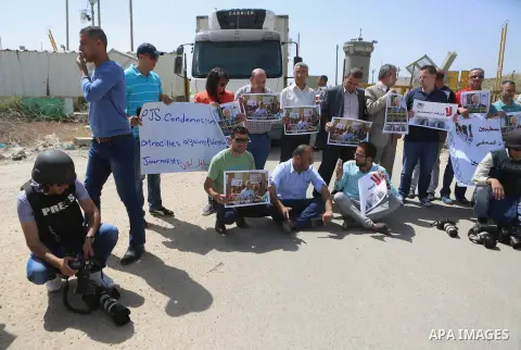 Palestinian journalists hold banners during a protest calling for the release of Palestinian journalist Omar Nazal, who is held by Israel, near Israel's Ofer Prison near the West Bank city of Ramallah April 26, 2016. Pho...