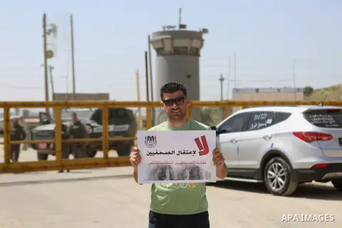 Palestinian journalists hold banners during a protest calling for the release of Palestinian journalist Omar Nazal, who is held by Israel, near Israel's Ofer Prison near the West Bank city of Ramallah April 26, 2016. Pho...