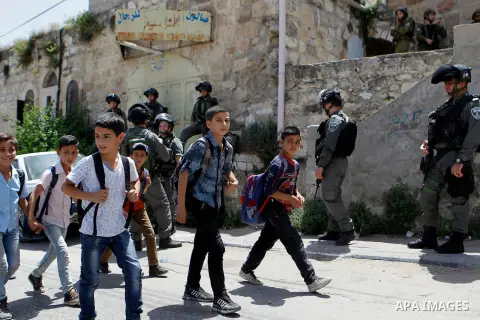 Israeli troops stand guard as Israeli settlers have a tour during the Jewish holiday of Passover in the West Bank city of Hebron, on April 26, 2016. Photo by Wisam Hashlamoun