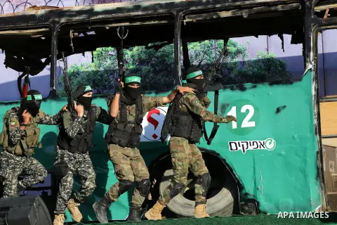Palestinian Hamas militants march in front of a mock burnt Israeli bus during an anti-Israel rally in Gaza city April 28, 2016. Photo by Mohammed Asad