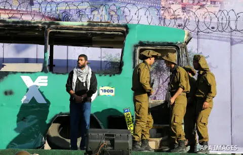Palestinian Hamas militants march in front of a mock burnt Israeli bus during an anti-Israel rally in Gaza city April 28, 2016. Photo by Mohammed Asad