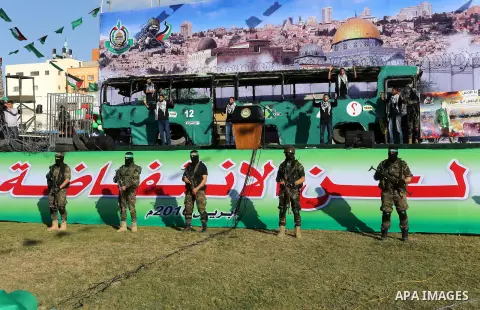 Palestinian Hamas militants march in front of a mock burnt Israeli bus during an anti-Israel rally in Gaza city April 28, 2016. Photo by Mohammed Asad