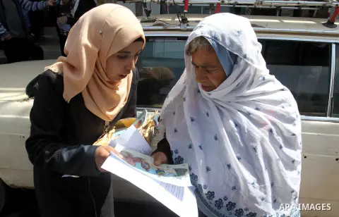 Palestinian women supporting Hamas movement distribute posters during awareness campaign against collaborate with Israel, in Rafah in southern Gaza strip, on April 30, 2016. Photo by Abed Rahim Khatib