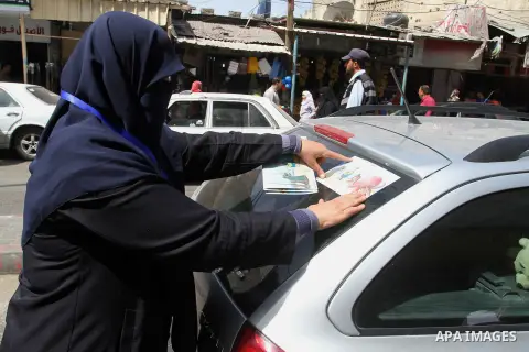 Palestinian women supporting Hamas movement distribute posters during awareness campaign against collaborate with Israel, in Rafah in southern Gaza strip, on April 30, 2016. Photo by Abed Rahim Khatib