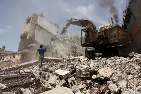 Palestinian men work on the remains of a building destroyed during the recent Israeli war 2014, in Shijaiyah neighborhood in the east of Gaza city, on April 30, 2016. Israel’s punitive ban on cement imports into the Gaza...