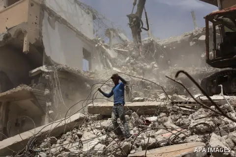 Palestinian men work on the remains of a building destroyed during the recent Israeli war 2014, in Shijaiyah neighborhood in the east of Gaza city, on April 30, 2016. Israel’s punitive ban on cement imports into the Gaza...