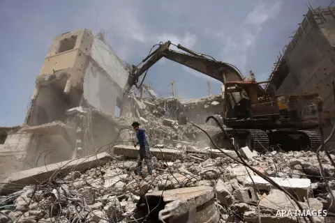 Palestinian men work on the remains of a building destroyed during the recent Israeli war 2014, in Shijaiyah neighborhood in the east of Gaza city, on April 30, 2016. Israel’s punitive ban on cement imports into the Gaza...