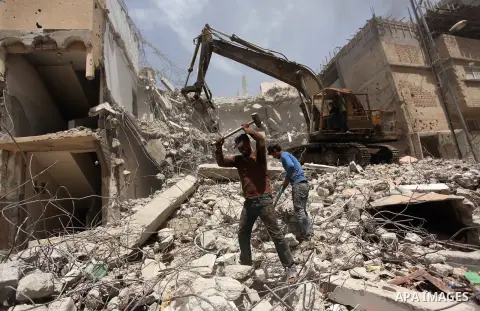 Palestinian men work on the remains of a building destroyed during the recent Israeli war 2014, in Shijaiyah neighborhood in the east of Gaza city, on April 30, 2016. Israel’s punitive ban on cement imports into the Gaza...