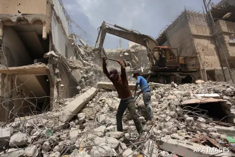 Palestinian men work on the remains of a building destroyed during the recent Israeli war 2014, in Shijaiyah neighborhood in the east of Gaza city, on April 30, 2016. Israel’s punitive ban on cement imports into the Gaza...