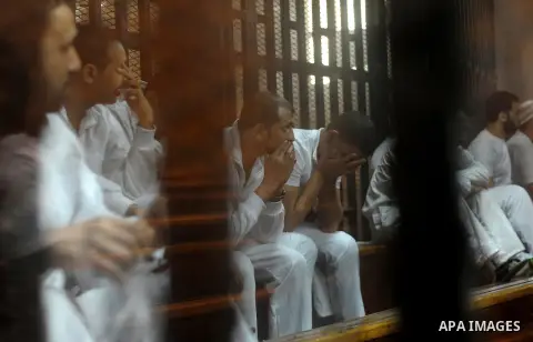 Egyptian defendants wait behind bars for the verdict in their retrial over a 2012 stadium riot in the canal city of Port Said at the police academy on the outskirts of the capital Cairo on April 30, 2016. Seven defendant...