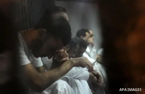 Egyptian defendants wait behind bars for the verdict in their retrial over a 2012 stadium riot in the canal city of Port Said at the police academy on the outskirts of the capital Cairo on April 30, 2016. Seven defendant...