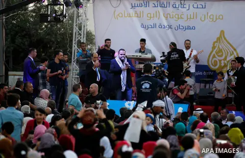 Palestinians take part in a opening ceremony of al-Hurria radio broadcasting office after the closure by the Israeli military, in the West Bank city of Hebron, on May 1, 2016. Photo by Wisam Hashlamoun