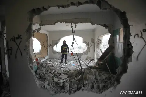 Palestinians look at the damage in the West Bank city of Nablus on May 3, 2016, after Israeli forces destroyed the house of Zaid Amer, a Palestinian man accused of taking part in the killing of a Jewish settler couple ne...