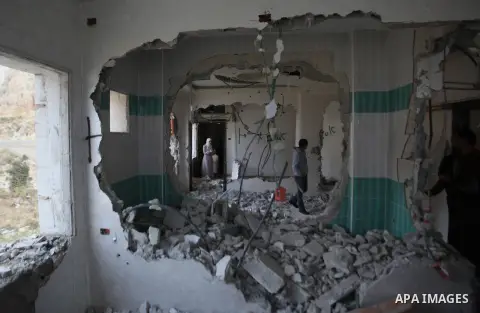 Palestinians look at the damage in the West Bank city of Nablus on May 3, 2016, after Israeli forces destroyed the house of Zaid Amer, a Palestinian man accused of taking part in the killing of a Jewish settler couple ne...