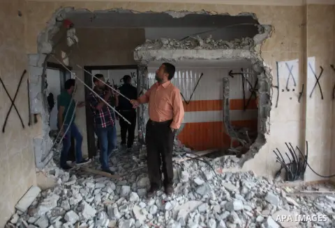 Palestinians look at the damage in the West Bank city of Nablus on May 3, 2016, after Israeli forces destroyed the house of Zaid Amer, a Palestinian man accused of taking part in the killing of a Jewish settler couple ne...