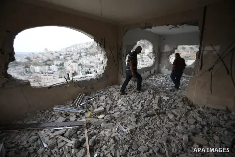 Palestinians look at the damage in the West Bank city of Nablus on May 3, 2016, after Israeli forces destroyed the house of Zaid Amer, a Palestinian man accused of taking part in the killing of a Jewish settler couple ne...