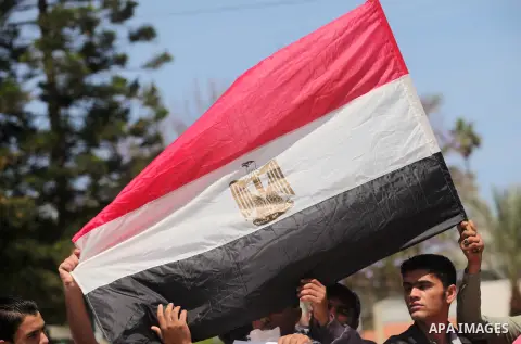Palestinians hold banners during a protest demanding the Egyptian authorities for the opening of the Rafah crossing, in Gaza, on May 4, 2016. Photo by Ashraf Amra