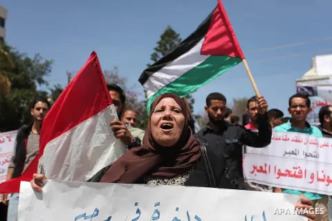 Palestinians hold banners during a protest demanding the Egyptian authorities for the opening of the Rafah crossing, in Gaza, on May 4, 2016. Photo by Ashraf Amra