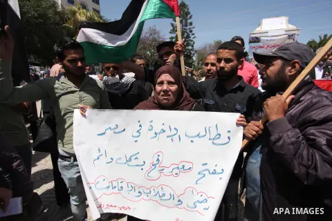 Palestinians hold banners during a protest demanding the Egyptian authorities for the opening of the Rafah crossing, in Gaza, on May 4, 2016. Photo by Ashraf Amra
