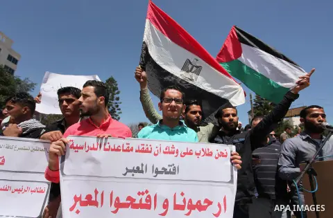 Palestinians hold banners during a protest demanding the Egyptian authorities for the opening of the Rafah crossing, in Gaza, on May 4, 2016. Photo by Ashraf Amra
