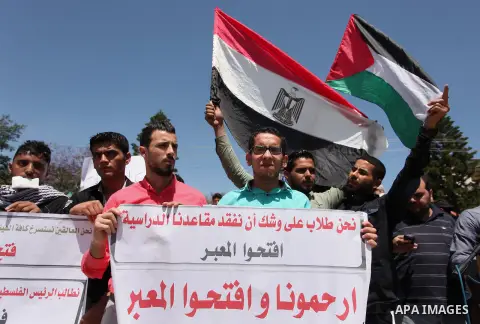 Palestinians hold banners during a protest demanding the Egyptian authorities for the opening of the Rafah crossing, in Gaza, on May 4, 2016. Photo by Ashraf Amra