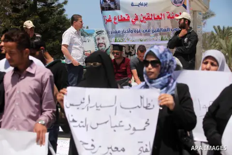 Palestinians hold banners during a protest demanding the Egyptian authorities for the opening of the Rafah crossing, in Gaza, on May 4, 2016. Photo by Ashraf Amra